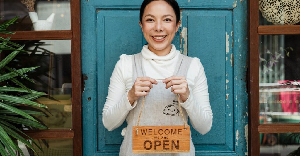 Small business owner with business sign after using best small business background checks