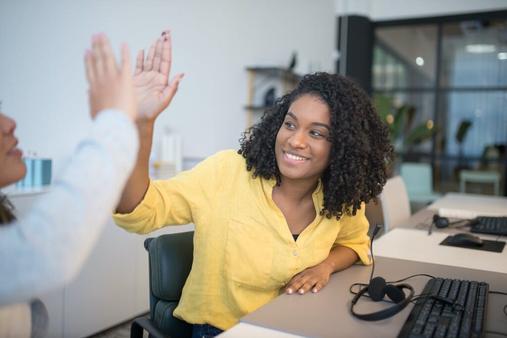 Employees high five to symbolize background check industry trends focus on customer experience