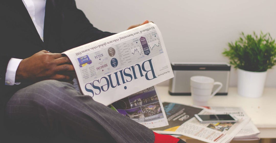 Financial services professional reading business section of newspaper