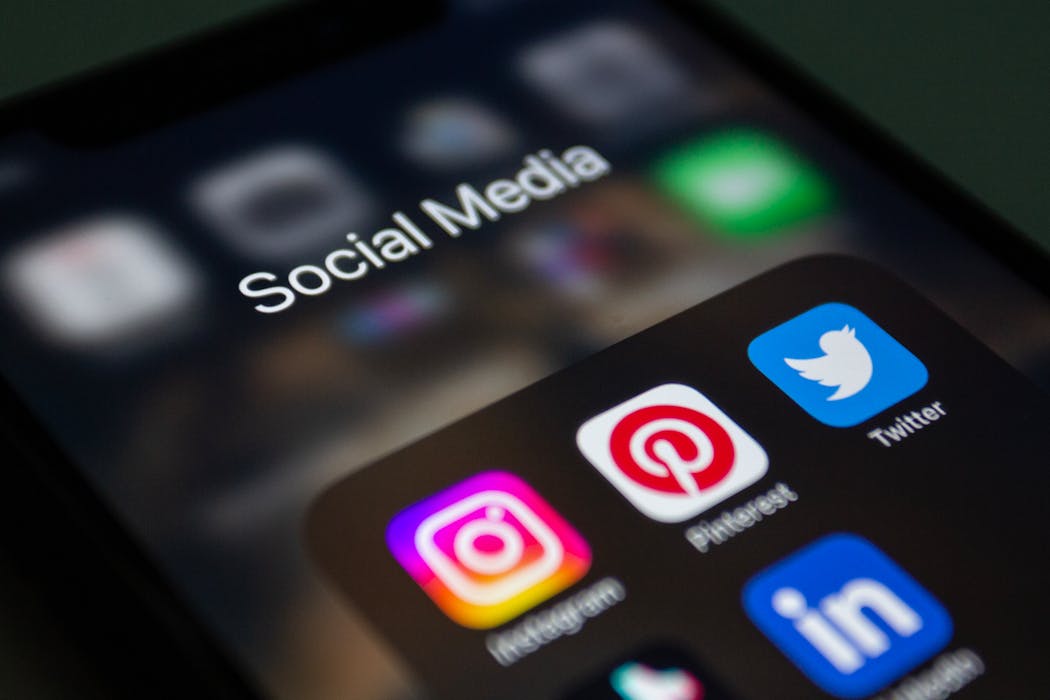 Smartphone screen displaying popular social media apps, highlighting the role of social media background checks in hiring practices