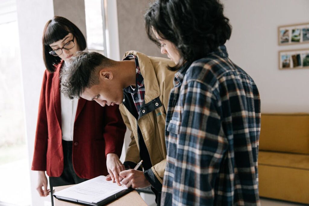Young, professional couple signing rental agreement with landlord after tenant screening services