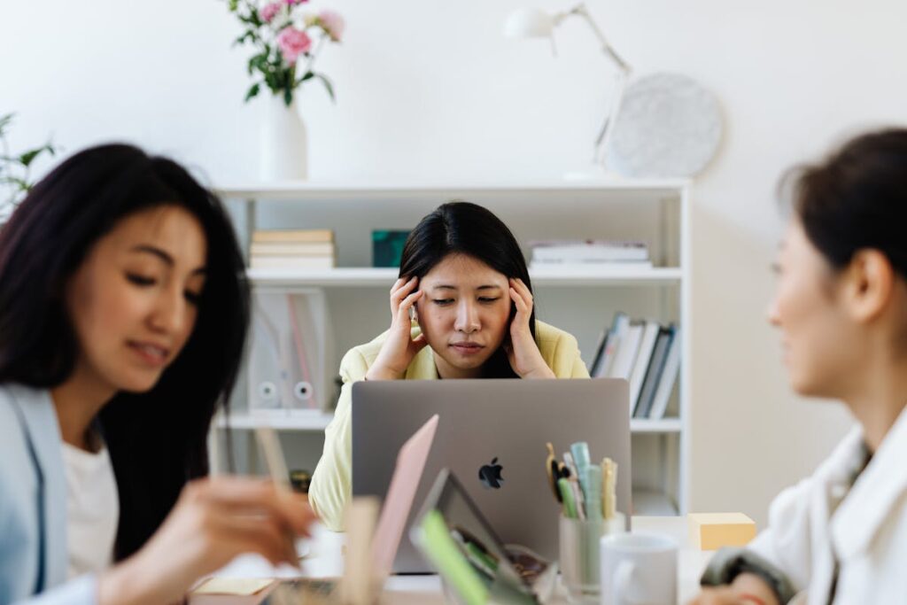Depiction of online background checks getting stuck causing TA leader to stress with headache