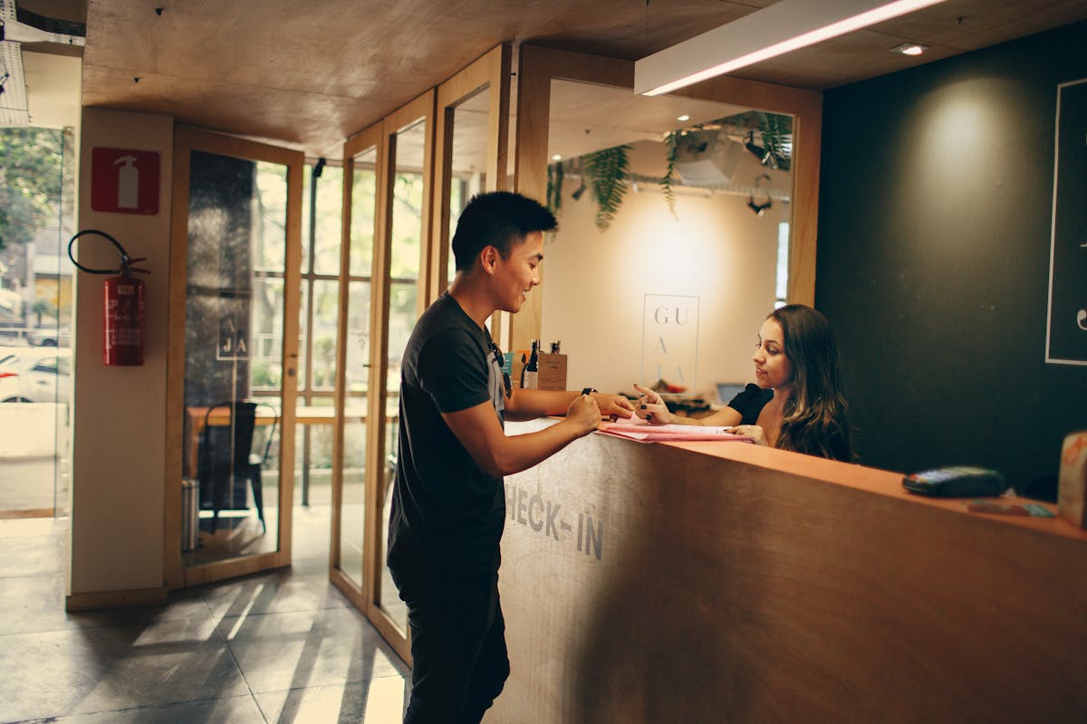 Guest checking in at reception with hotel concierge representing hotel hiring in 2025